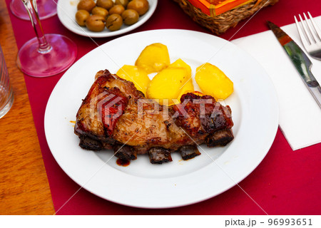 Honey glazed beef ribs with potato on table 96993651