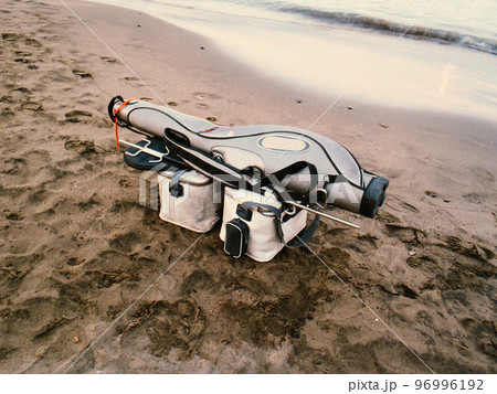 早朝の砂浜、渡船を待つ磯釣り用のタックルイメージ（ロッドケース、コマセバッカン、タックルバッグ） 96996192