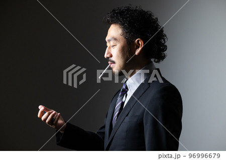 タバコを吸う髭の男性 96996679