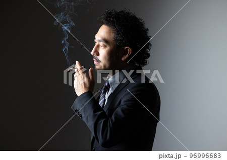 タバコを吸う髭の男性 96996683