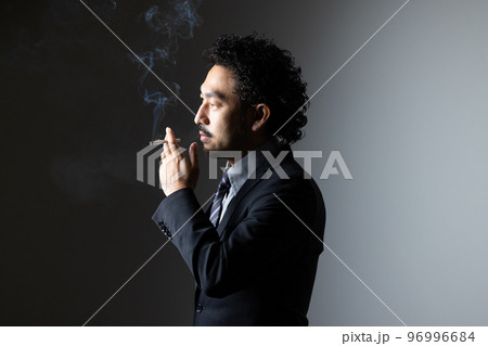 タバコを吸う髭の男性 96996684