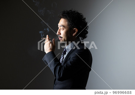 タバコを吸う髭の男性 96996688