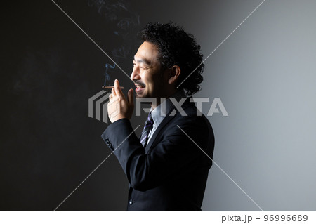 タバコを吸う髭の男性 96996689