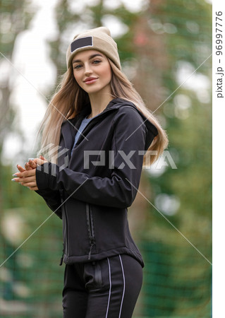 Portrait of a young adult blonde woman in sportswear and hat outdoors 96997776
