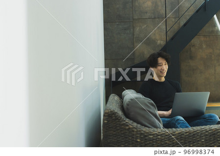 リビングでパソコンを見る男性 リビングでパソコンを見る男性 96998374