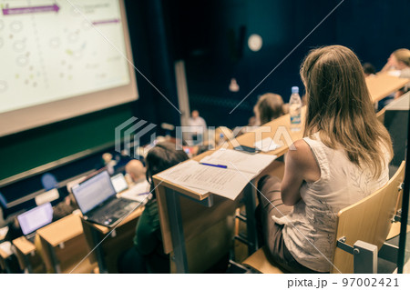 Conference and Presentation. Audience at the conference hall. Business and Entrepreneurship. Faculty lecture and workshop. Audience in the lecture hall. Academic education. Student making notes. 97002421