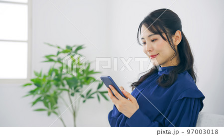 室内でスマホを使う女性 97003018