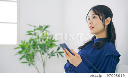 室内でスマホを使う女性 室内でスマホを使う女性 97003019