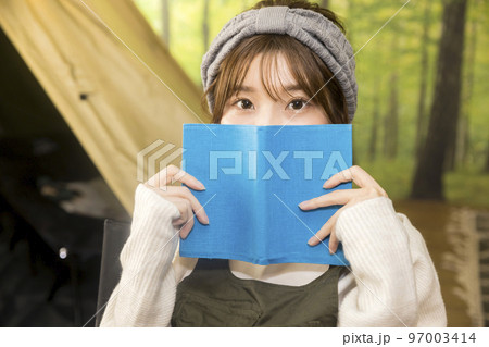 おうちキャンプイメージ　テントの前で読書をする若い女性 97003414