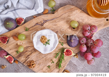 Camembert or brie cheese on wooden cutting board at domestic kitchen 97004419