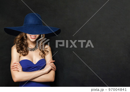 Fashion Portrait of Smiling Woman in Blue Dress and wide blue hat, Girl with Curly Hair 97004841