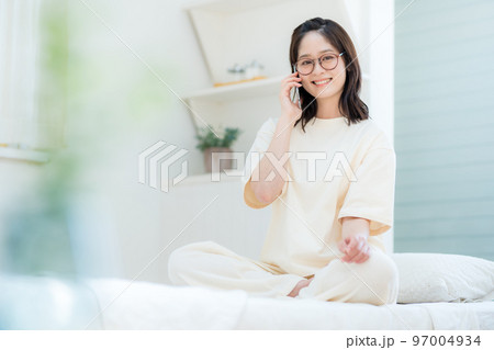 寝室で通話する若い女性 97004934