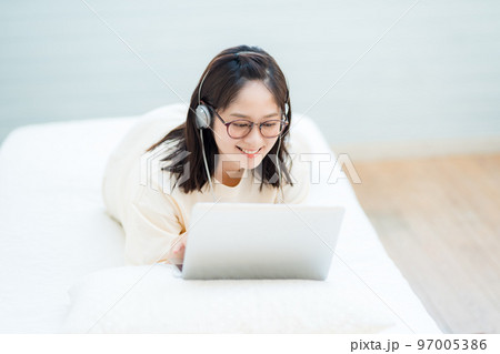 ノートパソコンで動画を視聴する若い女性 97005386