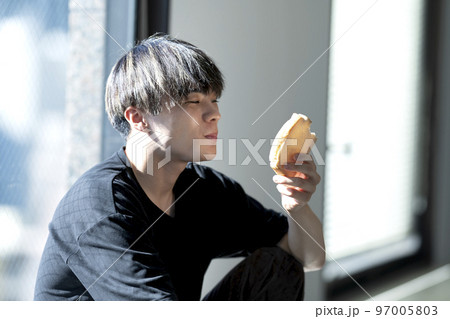 パンを食べる若い男性の写真素材 [97005803] - PIXTA