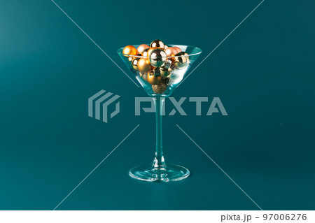 Glass with Christmas decorations on dark green background 97006276