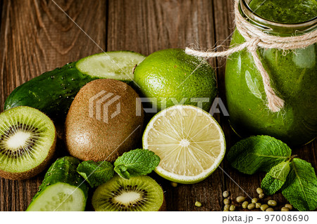 Blended green smoothie with ingredients on the wooden table. Green cocktail. Healthy food Blended green smoothie with ingredients on the wooden table. Green cocktail. Healthy food 97008690