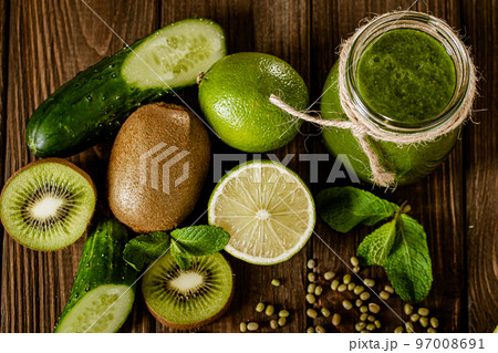 Top view of blended green smoothie with ingredients on the wooden table. Healthy food concept Top view of blended green smoothie with ingredients on the wooden table. Healthy food concept 97008691