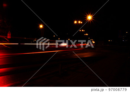 Lights of cars at night. Street line lights. Night highway city. Long exposure photograph night road. Colored bands of red light trails on the road. Background wallpaper defocused blurred 97008779
