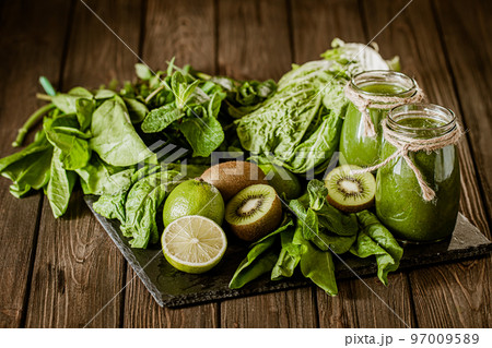 Blended green smoothie with ingredients on the wooden table. Green cocktail. Healthy food  97009589