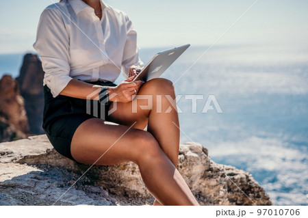Digital nomad, Business woman working on tablet pc pad computer by the sea. Pretty lady with tablet pc on the sea, makes a business transaction online from distance. Freelance, remote work on vacation Digital nomad, Business woman working on tablet pc pad computer by the sea. Pretty lady with tablet pc on the sea, makes a business transaction online from distance. Freelance, remote work on vacation 97010706