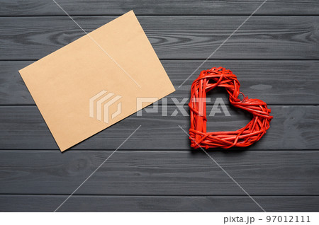 Love letter concept. Blank envelope on wooden plank table with heart shape aside 97012111