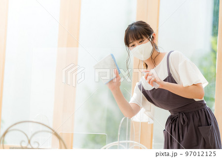 アクリルボードを消毒するカフェの女性店員 アクリルボードを消毒するカフェの女性店員 97012125