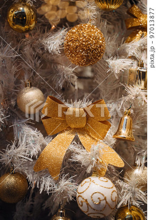 White and gold Christmas decorations on tree with balls bells and bows 97013877