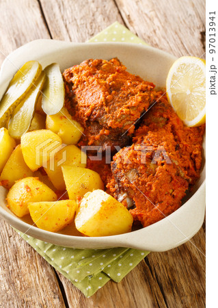 Macao fusion African chicken baked in spicy sauce with potatoes close-up in a pot on a table. Vertical Macao fusion African chicken baked in spicy sauce with potatoes close-up in a pot on a table. Vertical 97013941
