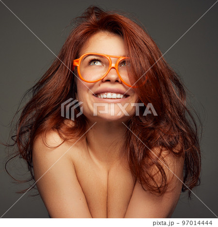 Portrait of young beautiful red-haired woman tenderly smiling isolated on dark grey background. Femininity Portrait of young beautiful red-haired woman tenderly smiling isolated on dark grey background. Femininity 97014444