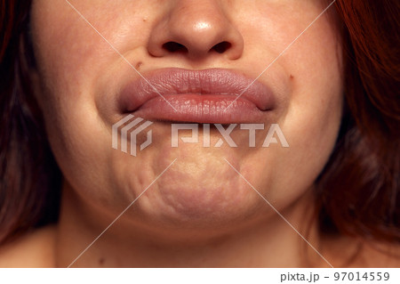 Close-up view of female perfect shape mouth with nude colored lipstick and chin. Grimace, Anti-wrinkles cosmetological care, face fillers Close-up view of female perfect shape mouth with nude colored lipstick and chin. Grimace, Anti-wrinkles cosmetological care, face fillers 97014559