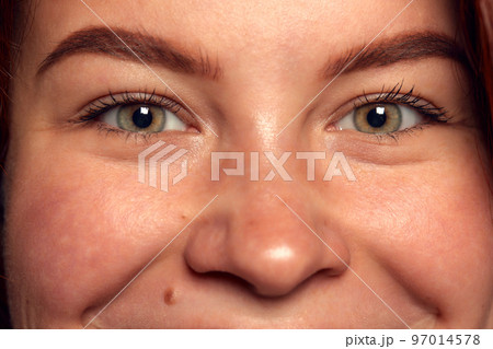 Smiling look. Close-up image of green-brown female eyes looking at camera. Emotions. Mimics. Concept of vision, contact lenses, medical care Smiling look. Close-up image of green-brown female eyes looking at camera. Emotions. Mimics. Concept of vision, contact lenses, medical care 97014578