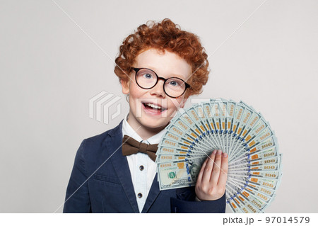 Happy child smart student boy in glasses and suit portrait with money us dollars fan Happy child smart student boy in glasses and suit portrait with money us dollars fan 97014579