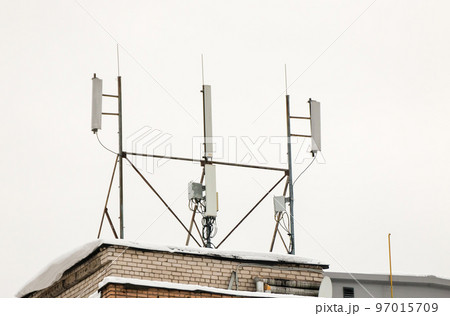 Several cellular antennas on the roof of the house provide communication. Several cellular antennas on the roof of the house provide communication. 97015709