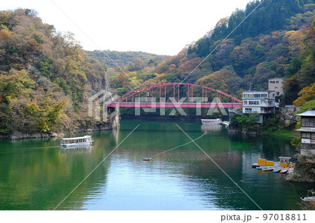 紅葉した秋の帝釈峡と神龍湖に架かる紅葉橋と遊覧船 97018811