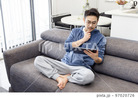 ソファーでタブレットを使う男性 97020726