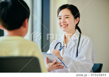 小学生の男の子を診察する若い女性医師 97020844