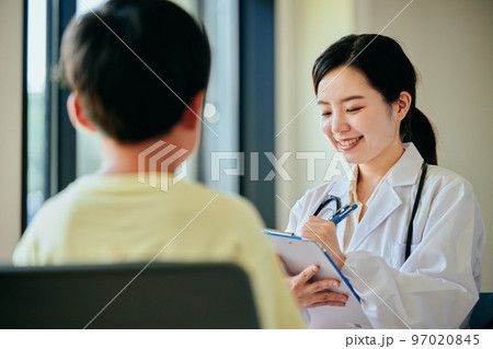 小学生の男の子を診察する若い女性医師 97020845