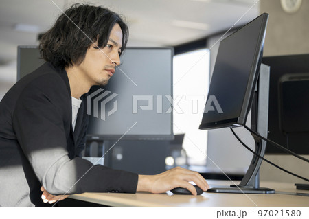 デスクトップパソコンで作業をする30代前半の男性 97021580