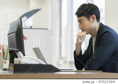 パソコンの画面を見ながら考え込むビジネスマン　横顔 97022364