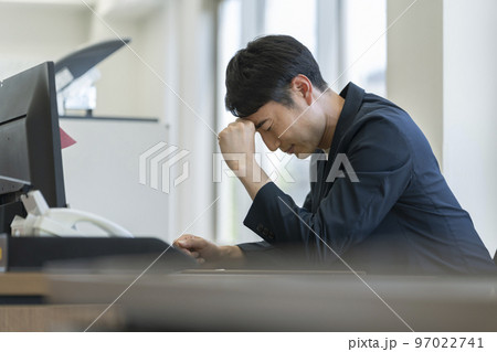 デスクで頭を抱える30代のビジネスマン 97022741
