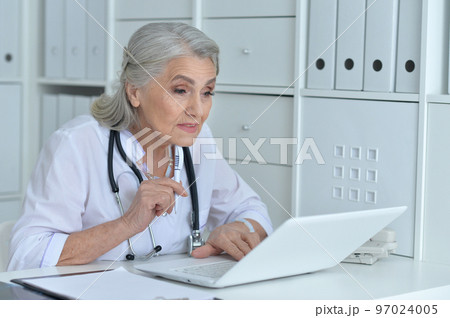old female doctor working at her cabinet 97024005