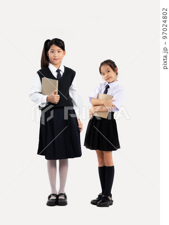 Asian girls junior student in school uniform holding book standing full length white background. 97024802
