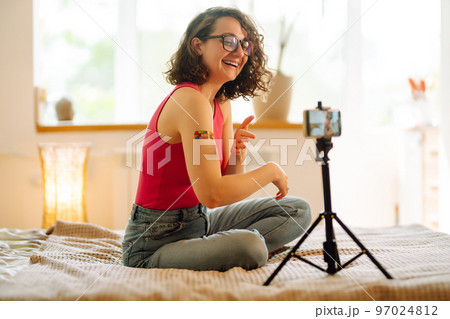 Woman blogger videotapes her vlog at home and speaking about Vaccine for covid-19. 97024812