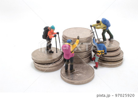 a mini climbers team climbing on stack of coins 97025920