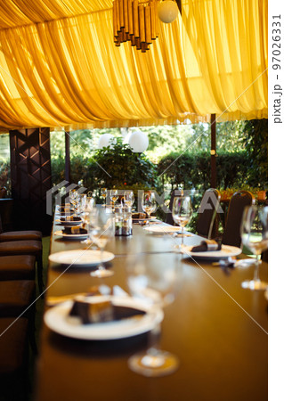 Sparkling glassware stands on long table prepared for wedding dinner. Sparkling glassware stands on long table prepared for wedding dinner. 97026331