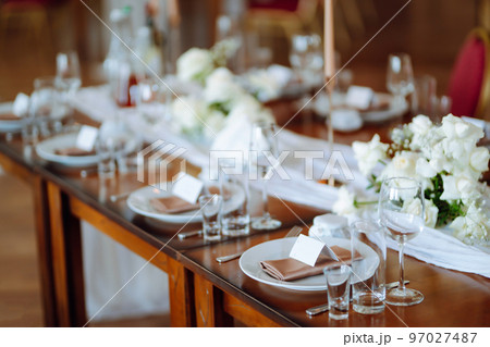 Beautiful table setting for a party, wedding reception or other festive event. Banquet setting, glasses, plates. Beautiful table setting for a party, wedding reception or other festive event. Banquet setting, glasses, plates. 97027487