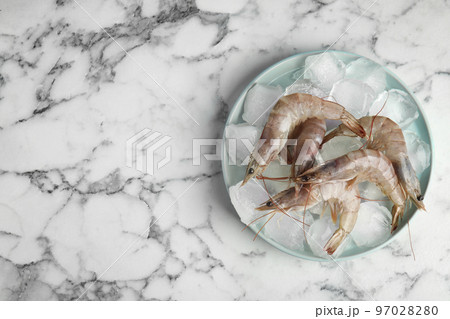 Raw shrimps with ice on marble table, top view. Space for text 97028280