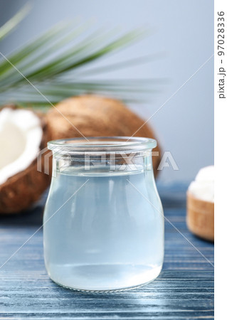 Coconut oil on blue wooden table, closeup view Coconut oil on blue wooden table, closeup view 97028336