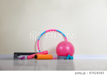 Different sports equipment near light wall in gym 97028365