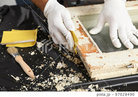 Man repairing old damaged window at table indoors, closeup 97028490
